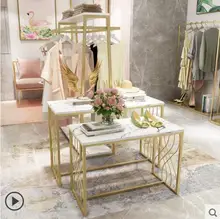 There are two rows of golden water display tables in the middle of the clothing store table
There are two rows of golden water display tables in the middle of the clothing store table