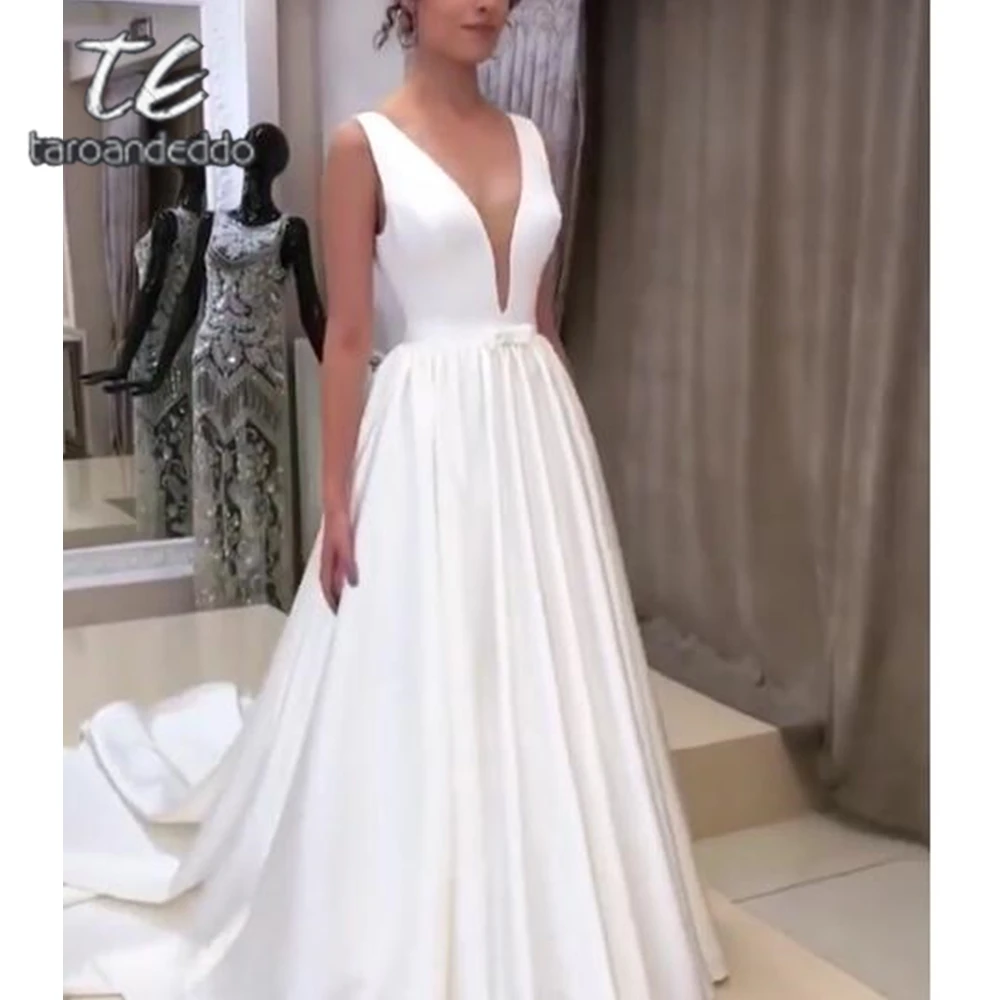 V Neck Wedding Dresses A Line Sleeveless Open Back Sweep Train Satin White Floor Length Bridal Dress with Sash Vestido De Noiva
V Neck Wedding Dresses A Line Sleeveless Open Back Sweep Train Satin White Floor Length Bridal Dress with Sash Vestido De Noiva