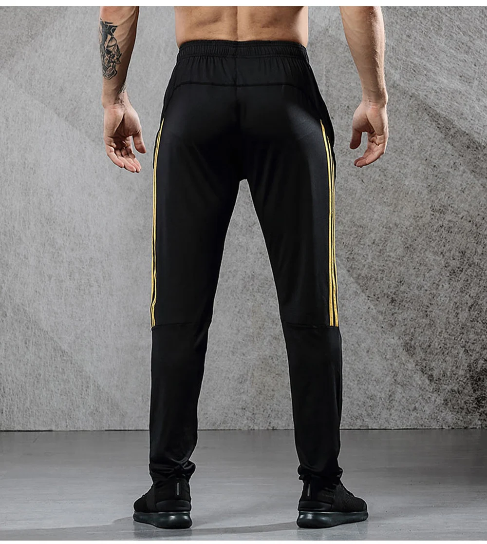 Image from the back men's breathable elastics pants for sport. Sport's breathable leggings for sport black with orange line color. Foto from the back men's breathable elastics pants for sport. Sport's breathable leggings for sport black with orange line color.