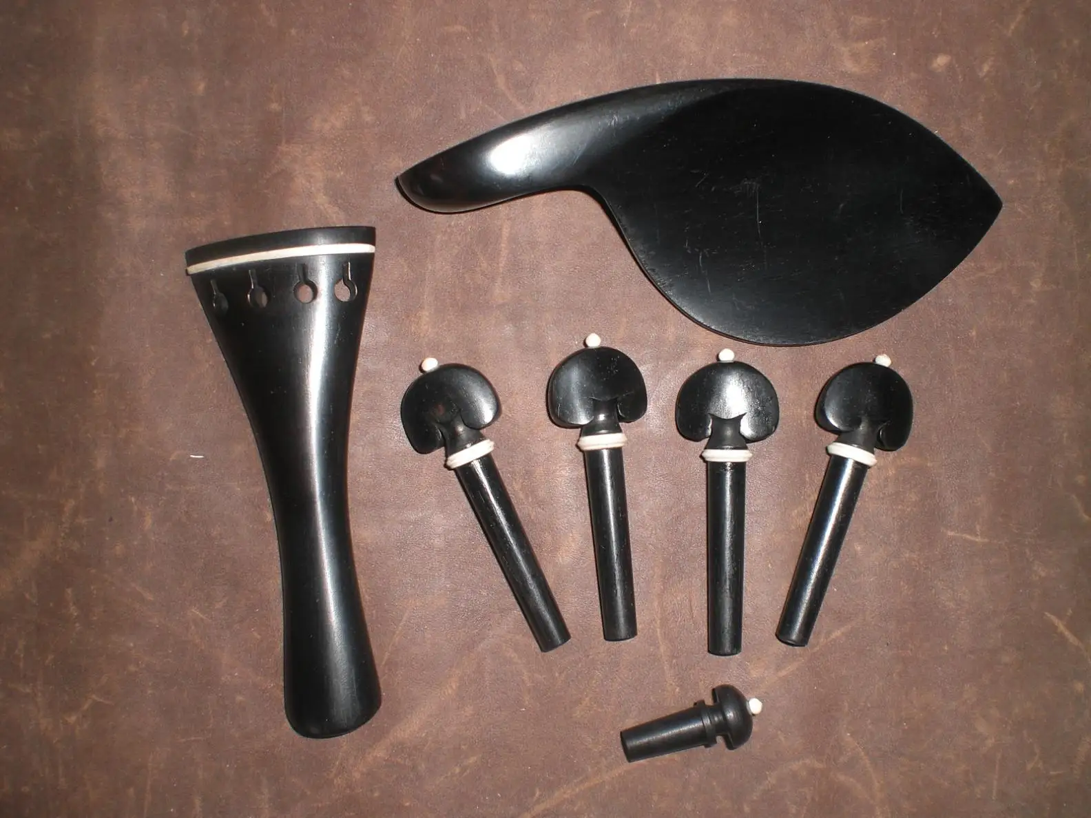 1 Set Ebony Violin Parts 4/4 with white bone collar including 1 tail piece 4 violin pegs 1 chin rest & end button
1 Set Ebony Violin Parts 4/4 with white bone collar including 1 tail piece 4 violin pegs 1 chin rest & end button