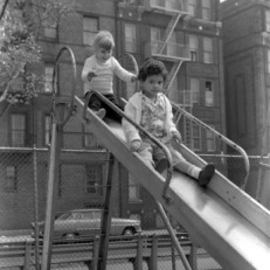 USA New York City New York Children on slide in front of apartment building Poster Print (24 x 36)
