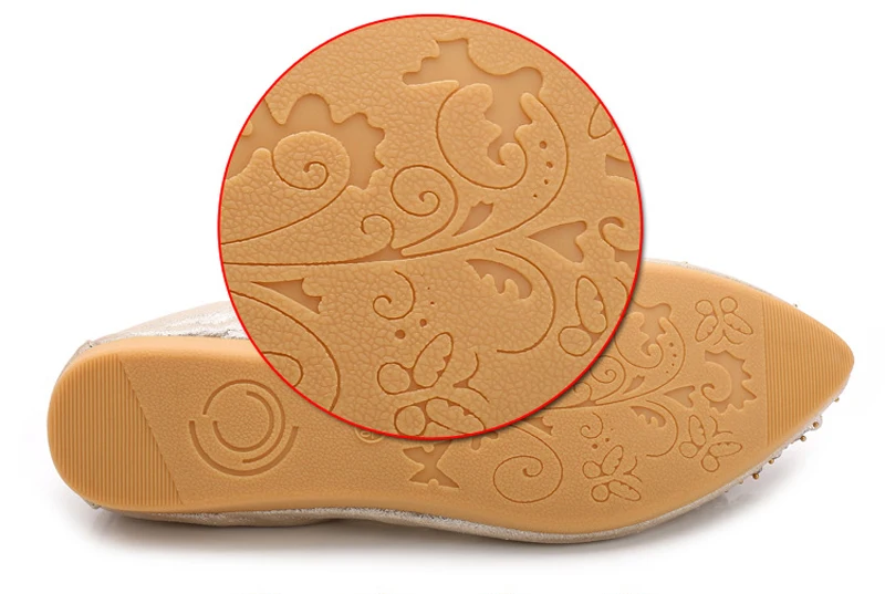 Close-up of intertwined floral pattern on a beige rubber outsole.