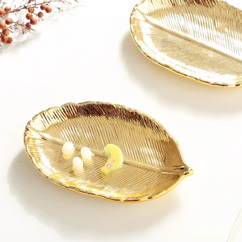 Nordic cosmetics gold-plated jewelry storage plate ceramic bedside table home docorative accessories holder creative gold leaf
Nordic cosmetics gold-plated jewelry storage plate ceramic bedside table home docorative accessories holder creative gold leaf