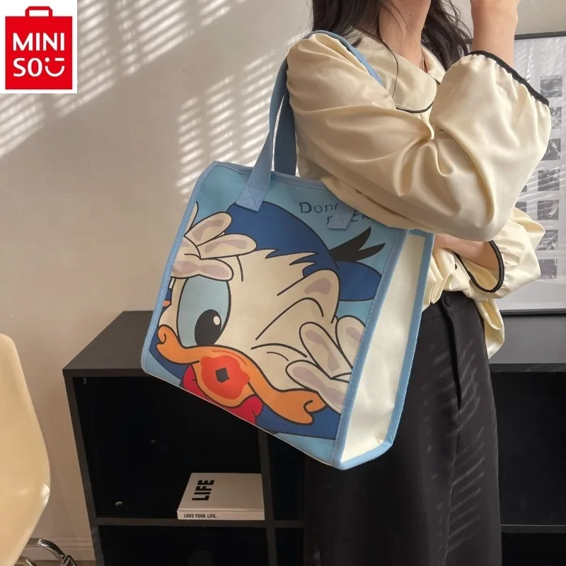 

MINISO Disney Donald Duck Mickey cartoon students shoulder canvas bag fashion ladies commuting large capacity portable tote bag.