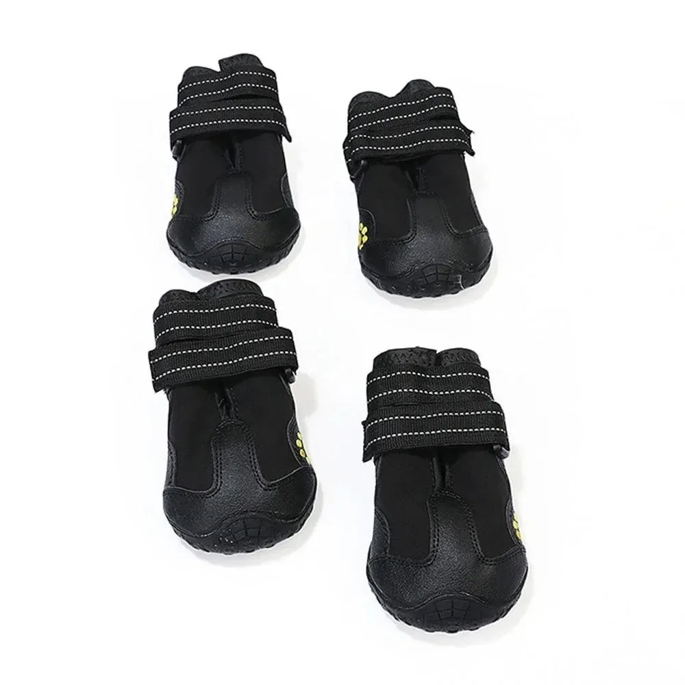 Dog Shoes | Waterproof Anti-Slip Rubber Dog Booties A set of four black dog shoes arranged in two rows. The shoes feature two adjustable reflective Velcro straps at the ankle and a reinforced rubber toe cap for durability.