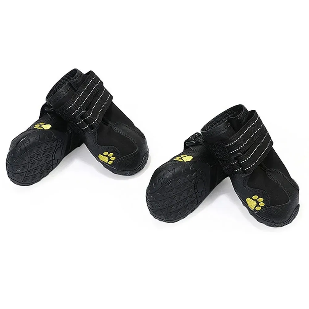 Dog Shoes | Waterproof Anti-Slip Rubber Dog Booties Two pairs of black dog shoes shown from different angles. One shoe in each pair is turned over to reveal a rugged, textured rubber sole with a non-slip pattern, while the side shows a small yellow paw print logo.