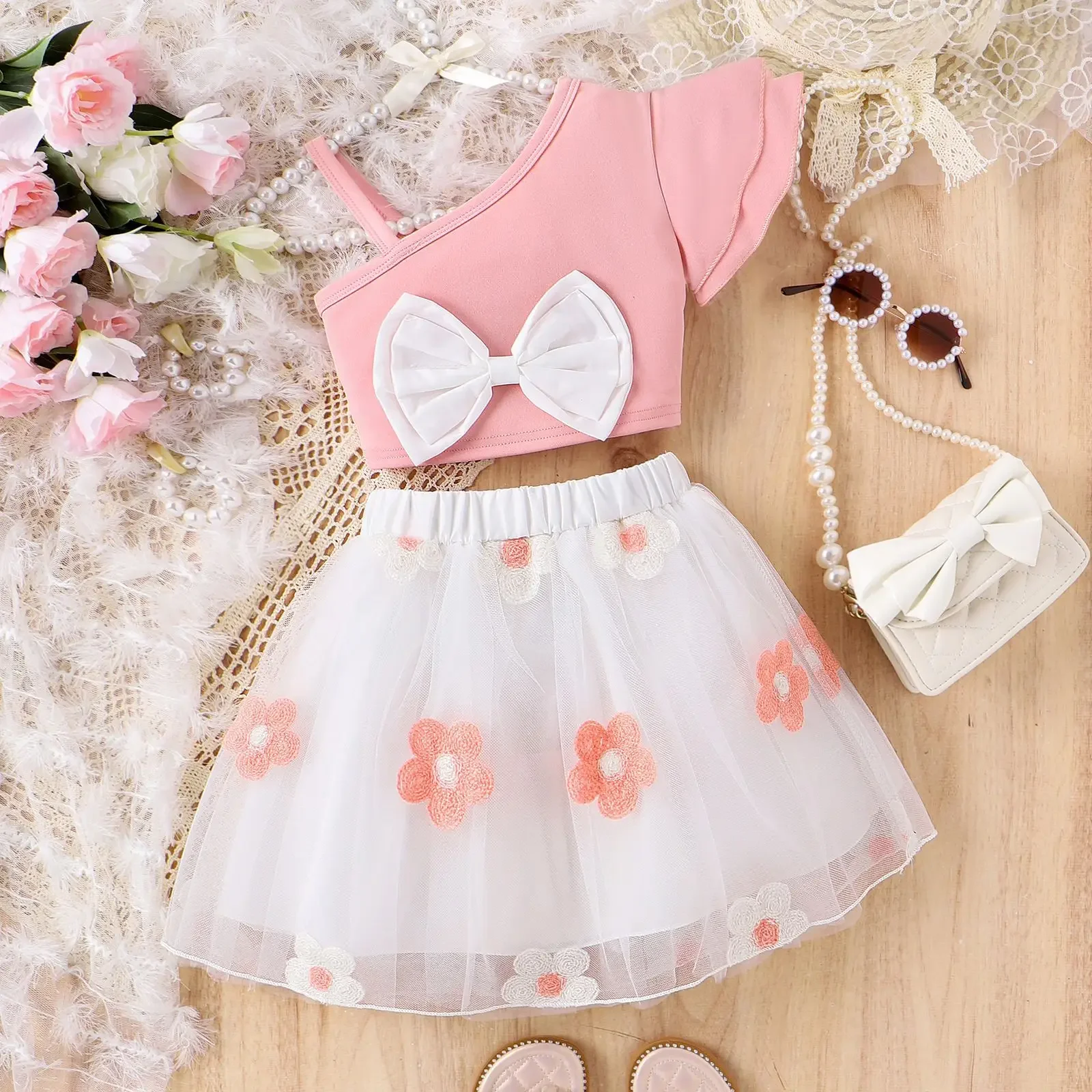 2024 Summer Girls Clothes Sets One-shoulder Ruffles Sleeve Bow Crop Tops + Flower Embroidery Gauze Skirt Kids Casual Clothing 
2024 Summer Girls Clothes Sets One-shoulder Ruffles Sleeve Bow Crop Tops + Flower Embroidery Gauze Skirt Kids Casual Clothing