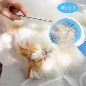 Self-Cleaning Pet Brush | Dogs & Cats, Grooming Tool Close-up of a person’s hands using a white grooming brush with a blue button to gently brush the neck area of a grey British Shorthair cat.