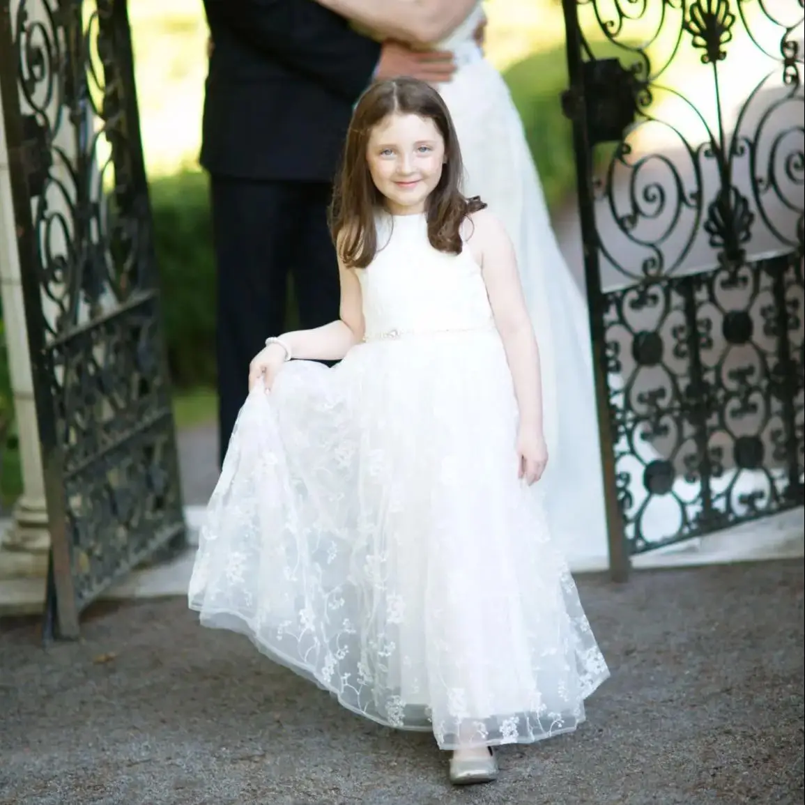 

FATAPAESE Sleeveless fleur lace flower girl dress w/ jewel neckline and full shirred tulle skirt. 3/8" grosgrain ribbon belt at