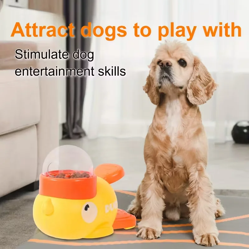 Interactive Dog Feeding Toy | Automatic Cartoon Duck Design A Cocker Spaniel sitting attentively on a grey mat next to a yellow and orange duck-themed puzzle feeder. Large orange text above the dog reads "Attract dogs to play with" and "Stimulate dog entertainment skills."