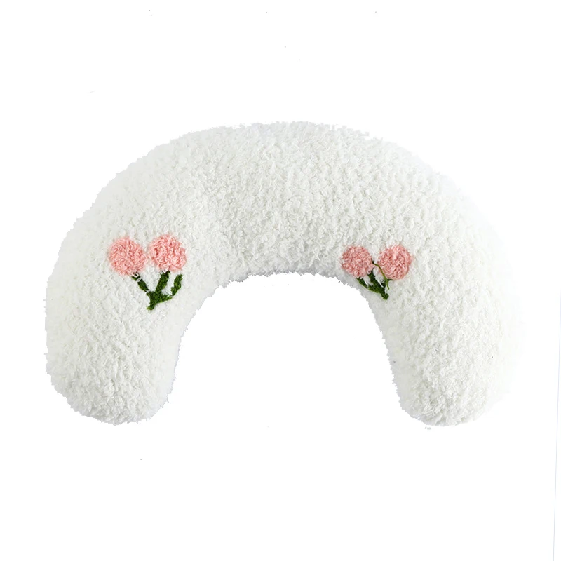 White, crescent-shaped cushion with a textured surface and two small embroidered pink flowers on either end, The Stuff Box Cozy Pet Pillow for Cats and Small Dogs is perfect for your furry friend's comfort.
