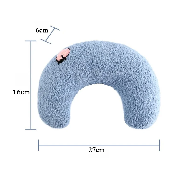 A calming blue, U-shaped plush pillow with a pink patch, measuring 27 cm in width, 16 cm in height, and 6 cm in depth. This Cozy Pet Pillow for Cats and Small Dogs by The Stuff Box is made from soft and cozy material.