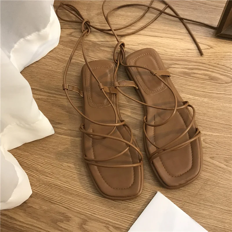 Yeni 2022 sandalet kadın yaz plaj moda seksi düz rahat çapraz kravat burnu açık peri tarzı dar bant ayakkabı siyah roma sandalet Yeni 2022 sandalet kadın yaz plaj moda seksi düz rahat çapraz kravat burnu açık peri tarzı dar bant ayakkabı siyah roma sandalet
