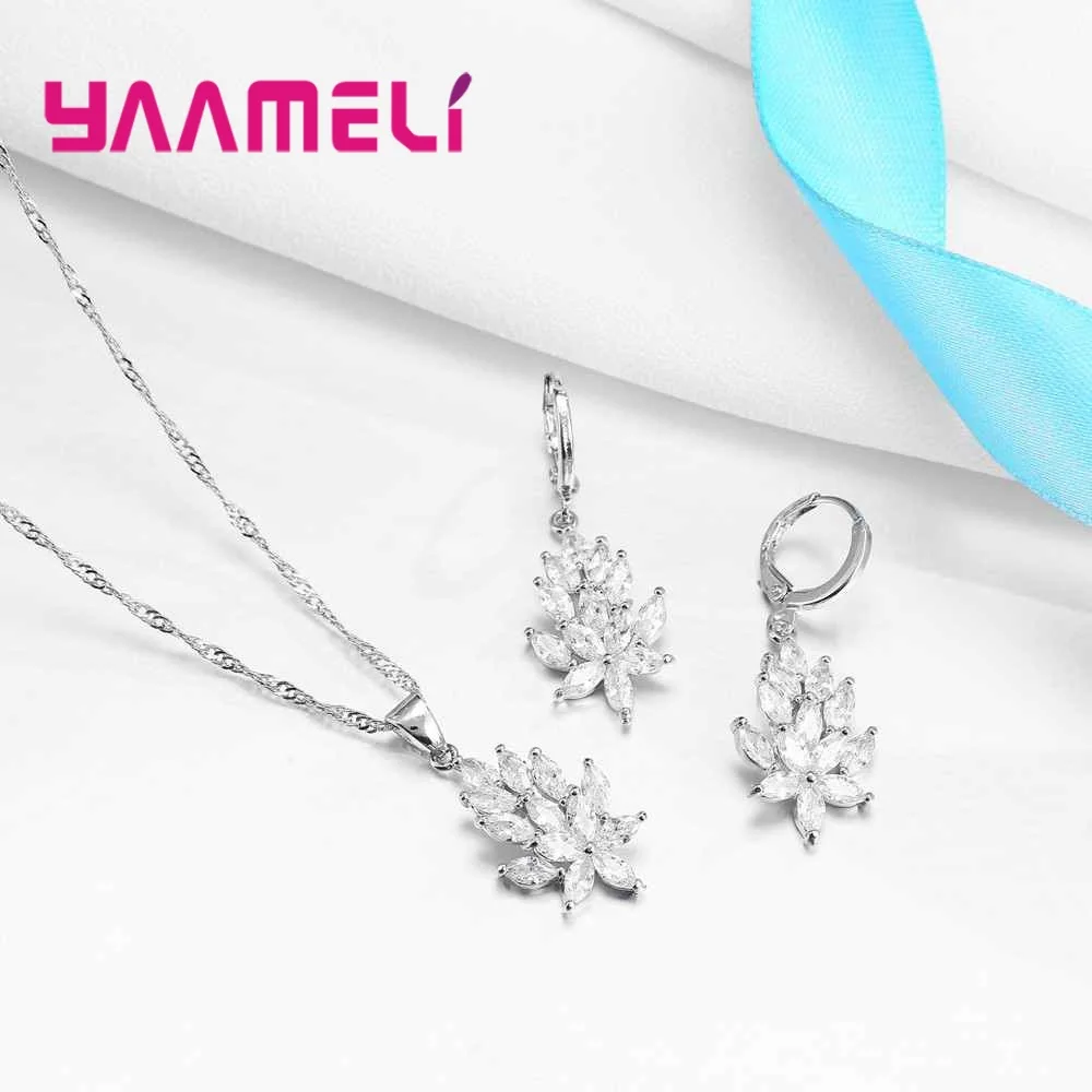 Conjunto de joyería de hoja de cristal plateado que incluye un collar de colgante con forma de hoja de plata y pendientes a juego con acentos de cristal transparente sobre una cadena delicada y cierres tipo palanca.