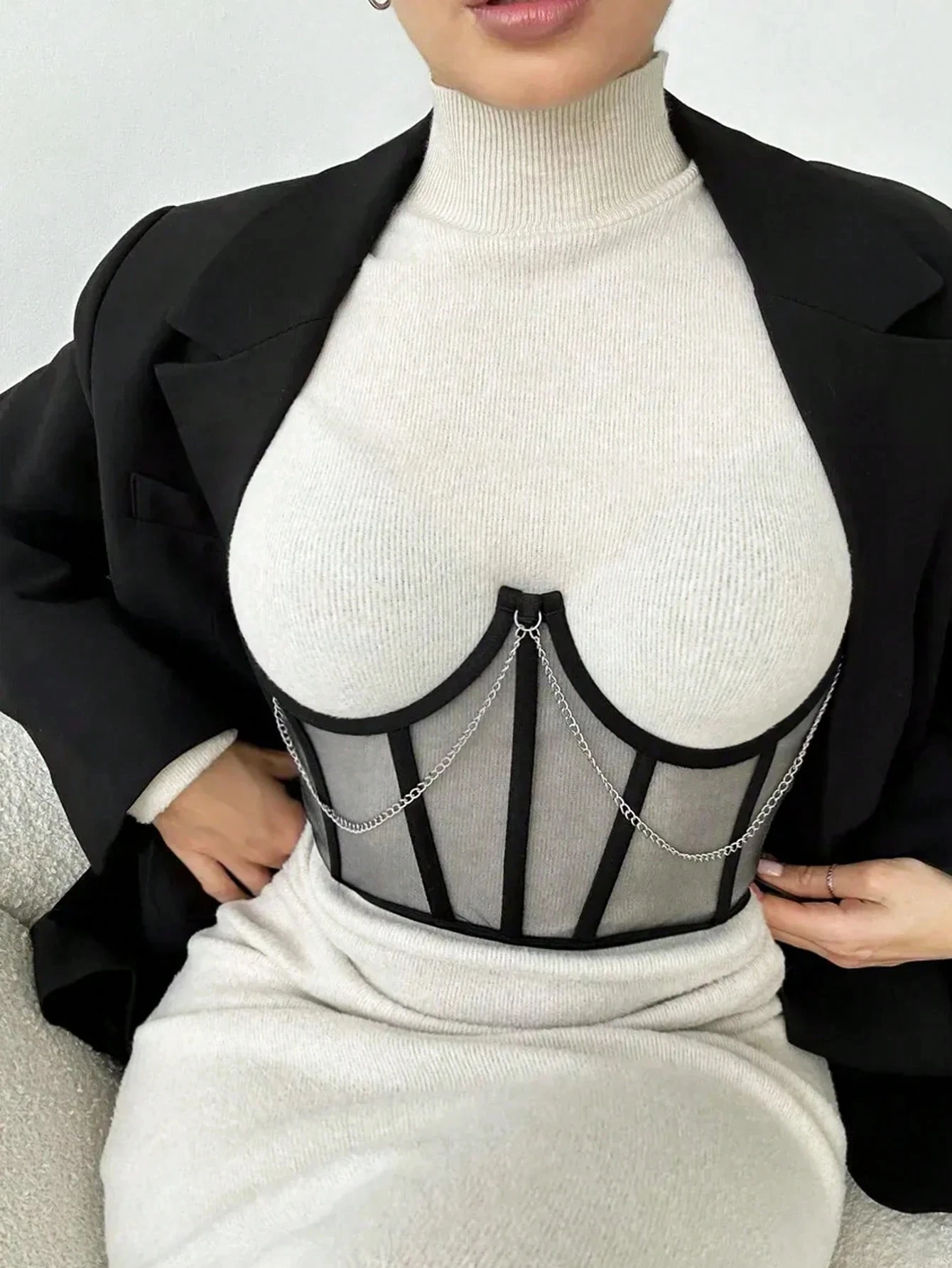 Black sheer layering piece styled over a cream turtleneck dress
