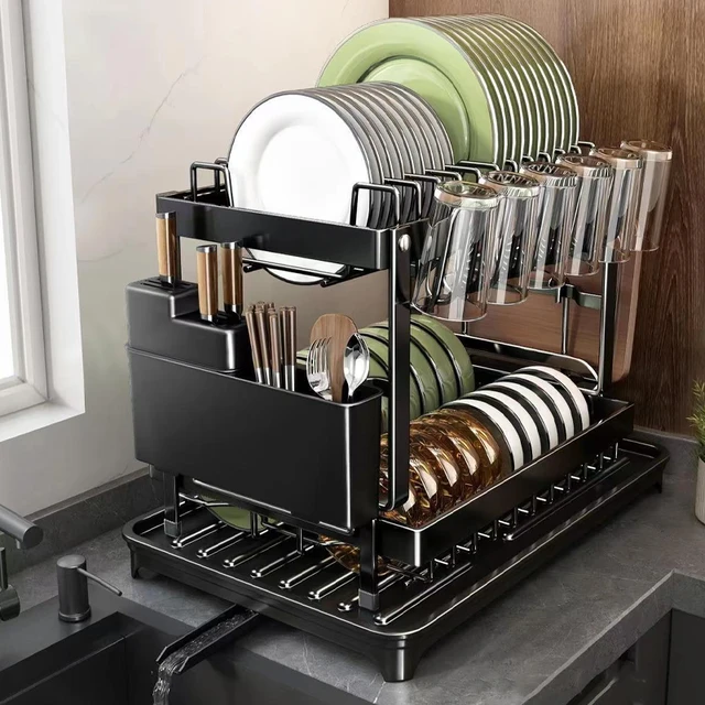 A modern, black 2 tier dish drying rack sitting on a kitchen counter, neatly holding clean white plates, bowls, and cutlery.