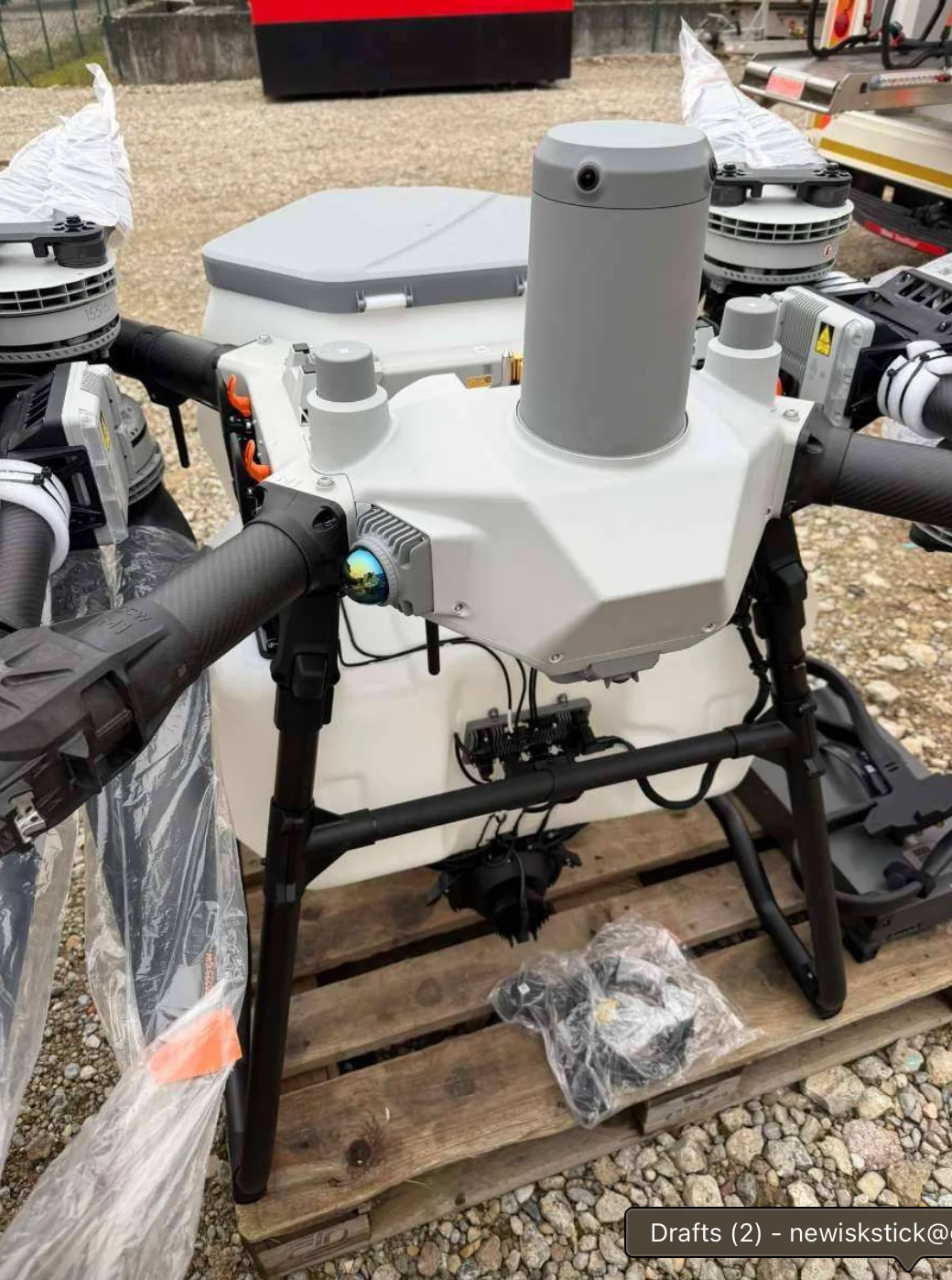 Drone agricole professionnel 10L pulvérisation pesticides GPS atterrissant sur une piste en terre.