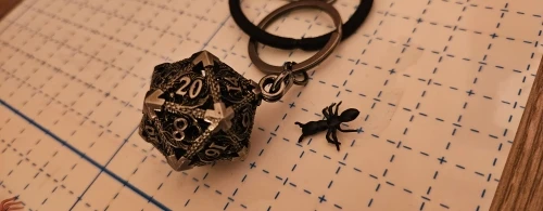 Porte-clés pendentif D20 creux bronze avec mini set de dés JDR
