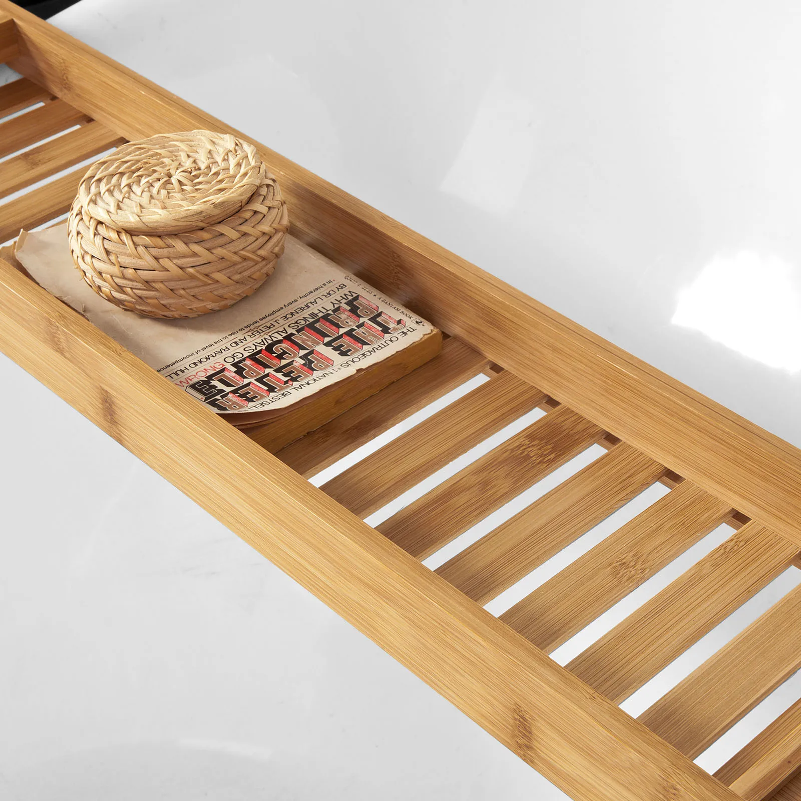 Wicker-schaal en boek op de bamboe badplank, badkuip-detail