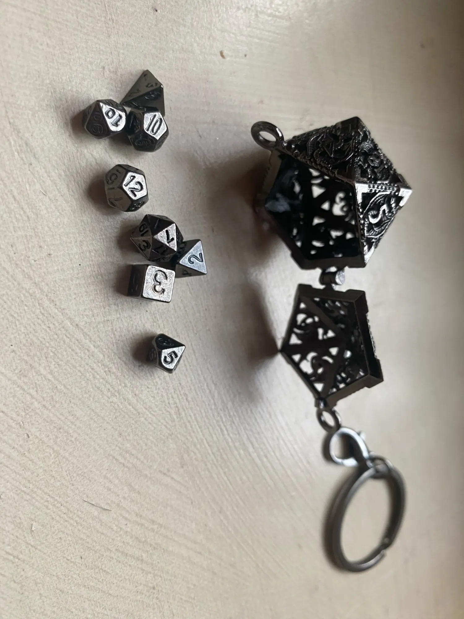 Porte-clés pendentif D20 creux argenté avec mini set de dés JDR