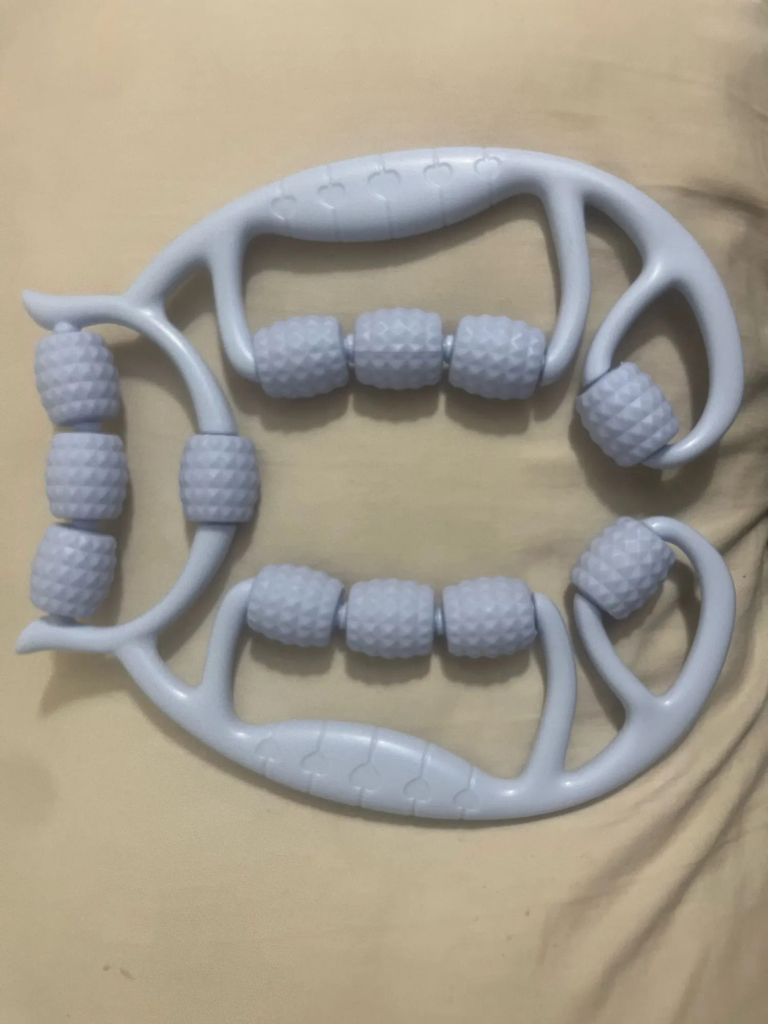 A versatile 12-wheel massage roller designed to relieve tension in legs, arms, back, shoulders, and neck. photo review