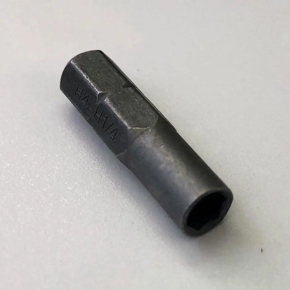 Mains tenant l'adaptateur porte-embout micro 1/4" pour tournevis de précision, outil d'entretien, montrant sa petite taille.