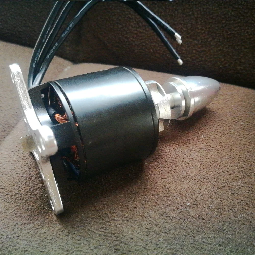 Moteur Brushless 1000KV 129g pour RC posé sur une surface blanche, avec une pièce de monnaie pour échelle.