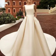 Свадебное Платье трапециевидного силуэта со шлейфом с бантом цвета шампанского, белого, цвета слоновой кости без рукавов с открытой спиной и карманами на пуговицах свадебные пояса невесты