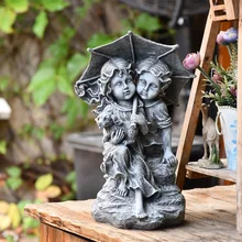 Мальчик и девочка держат щенка и зонтик на каменном саду Скульптура дома украшения статуи Открытый Декор Пейзаж ремесла