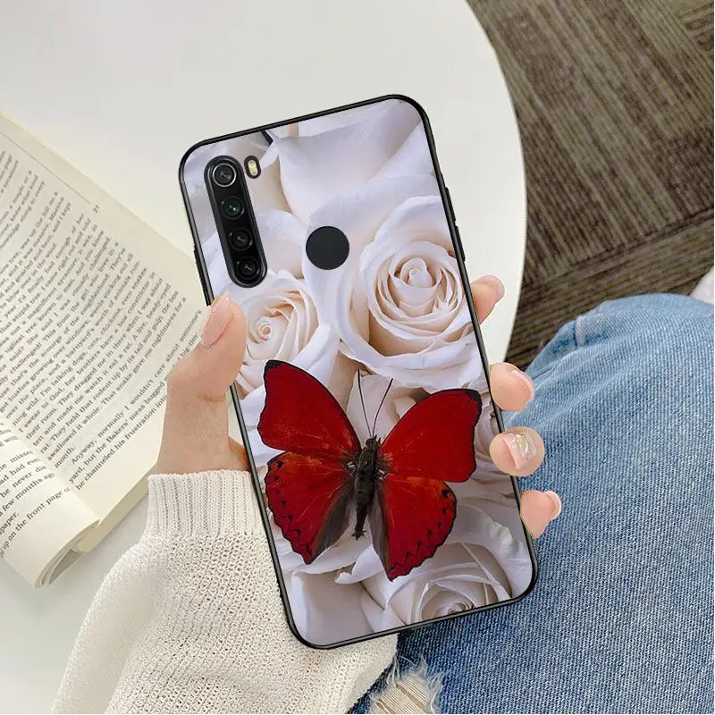 Red butterfly on white roses flower