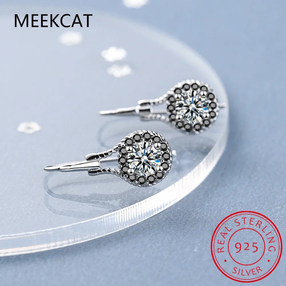 Boucles d’oreilles pendantes en spinelle noir avec argent sterling comprenant une tige centrale en diamant rond taillé brillant, entourée d’un halo de pierres d’accent gris foncé.