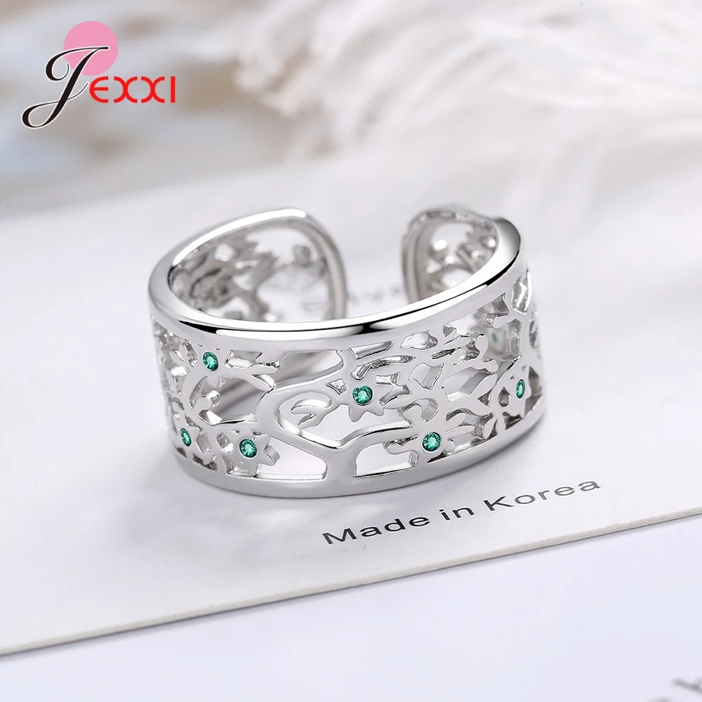 Anneau ouvert arbre de vie en argent par jexxi, avec un motif filigrané complexe et des pierres de zircon vert intégrées dans l’argent sterling.