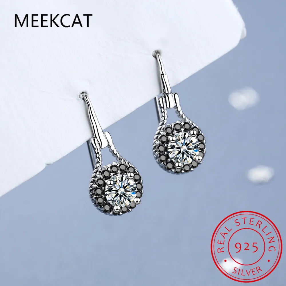 Boucles d’oreilles pendantes en spinelle noir avec argent sterling comprenant une cristale centrale transparente entourée de cristaux gris foncé plus petits, avec une fermeture à crochet élégante.