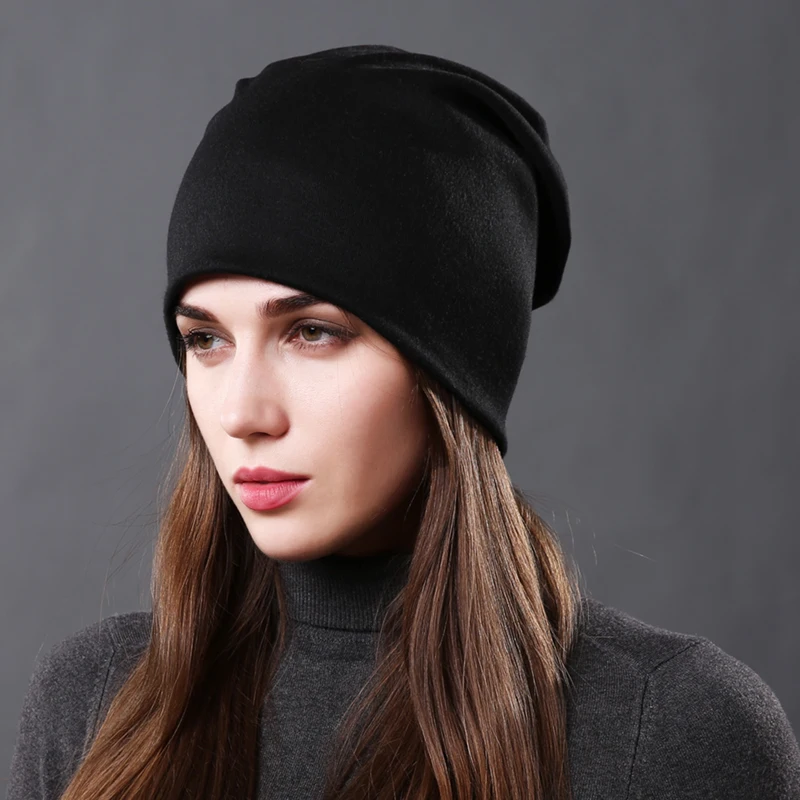 bonnet noir en cotton lâche avec bord roulé sur une femme brune