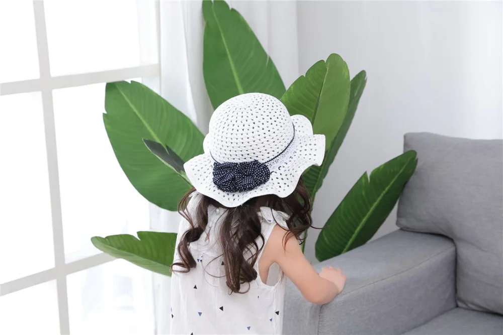 Empty dark blue polka dot flowers on white children's straw hat children's sun hat spring summer hat