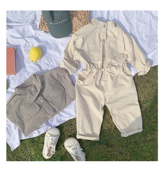 

WORKER PLAYSUIT -Round neck jumpsuit with long sleeves. Snap button fastening and front pockets. Loops at the waist