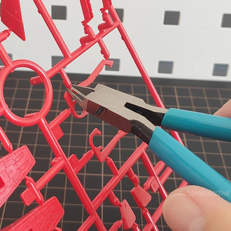 Vue de profil de la pince à buse à lame fine, outil de précision pour modèles réduits avec ressort de rappel.
