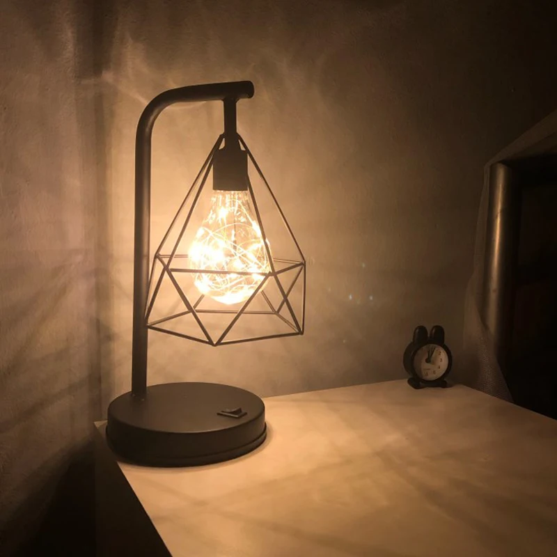 Preise Retro Eisen Kunst Minimalistischen Tisch Lampe AA Batterie Hohlen Diamant Form Lesen Lampe Vintage NightLamp Für Schlafzimmer Nacht Beleuchtung