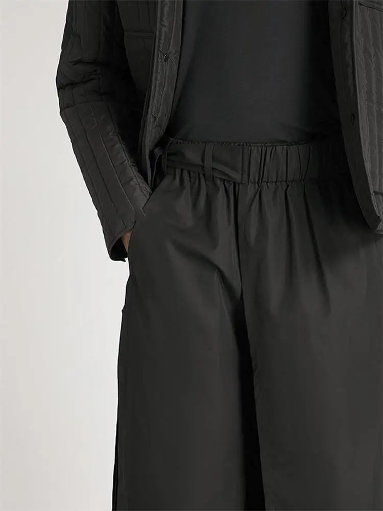The new men\'s cropped trousers are dark and large size loose trousers with irregular asymmetrical wide legs