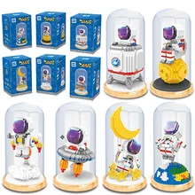 Bloques de construcción de astronauta se insertan en el espacio, y la gente hace pequeñas partículas micro taladro espacial y juguete de aviación adorno de regalo
