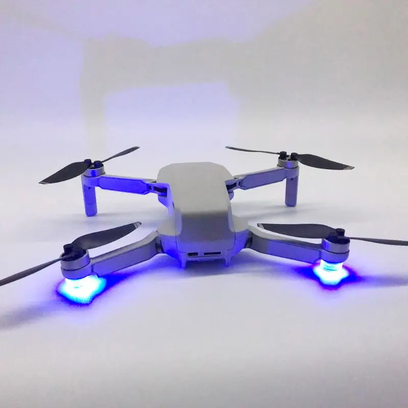 Drone DJI Mavic Mini en vol avec les lampes LED anti-perte allumées, visibles dans le ciel nocturne.