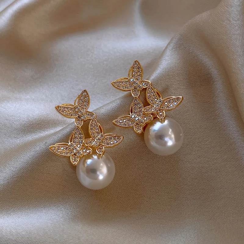 

Dainty Female White Pearl Stud Earrings Simple Gold Color Peary Earrings Classic Crystal Butterfly Wedding Earrings For Women