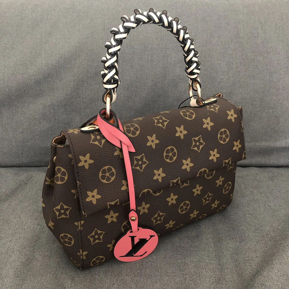 

The Cluny medium bag is embellished with a woven handle for the Monogram canvas body. Detachable leather shoulder strap