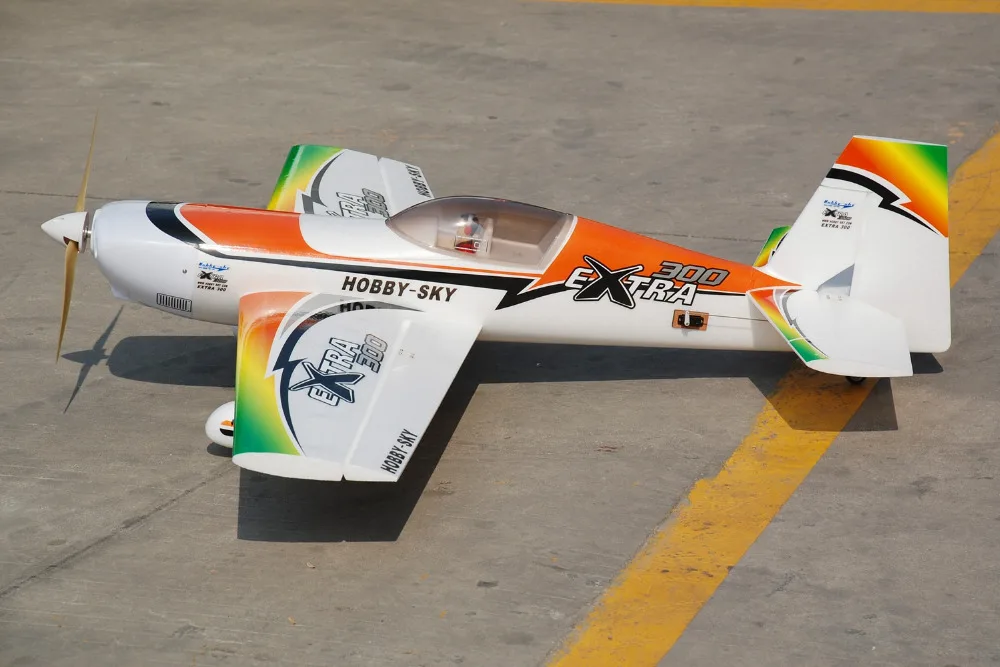 Avion RC EXTRA300 PNP posé sur l'herbe, mettant en valeur sa construction premium.