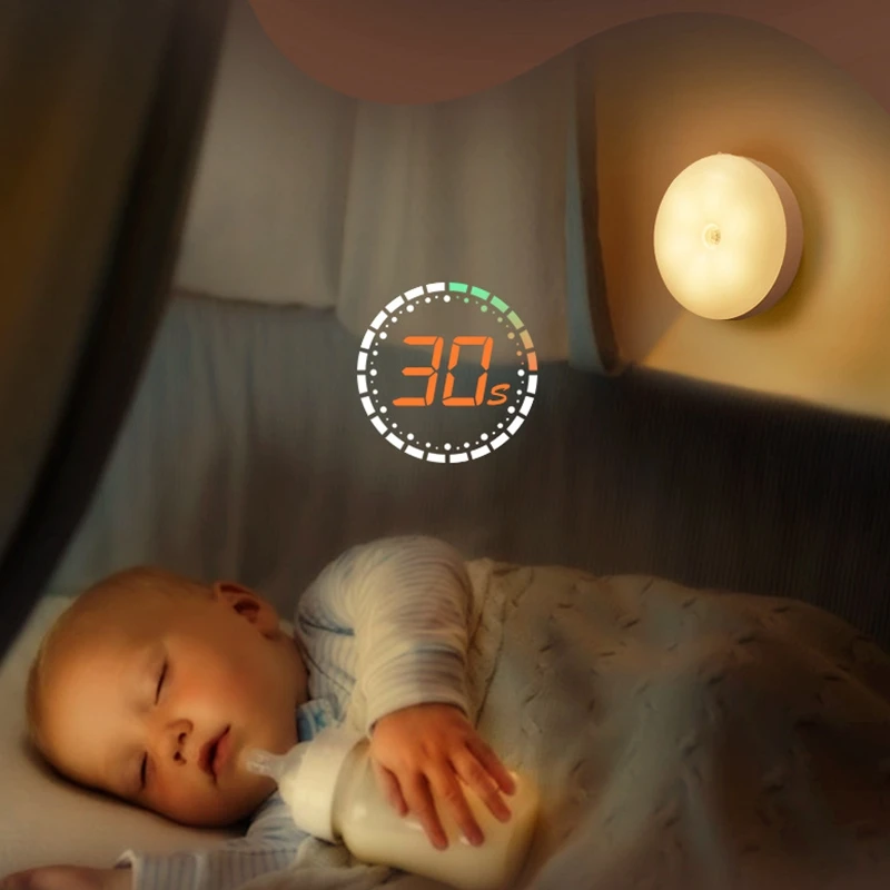 A baby is sleeping in a bed with a Brookline Shop PIR Motion Sensor LED Night Light USB Rechargeable on.