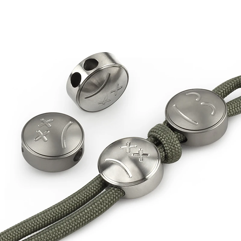 

1pcs Titanium Alloy EDC Knife Bead Polishing Sand Blasting Emoji Expression Design Umbrella Rope Buckle DIY Paracord Pendant