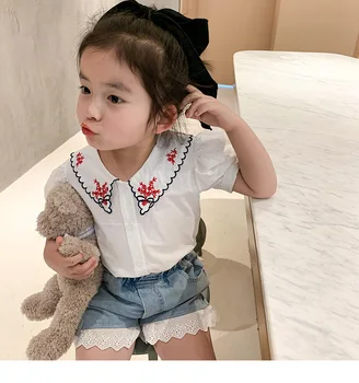 

EMBROIDERED GINGHAM BLOUSE -peter pan collar and short buttoned sleeves. Button-up front. Gingham print and embroidered motifs.