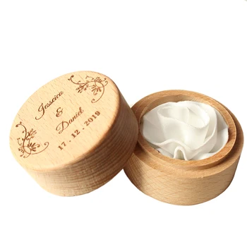 

A customized wooden wedding ring box, 5.2cm in diameter, with hand-made white rose flowers inside