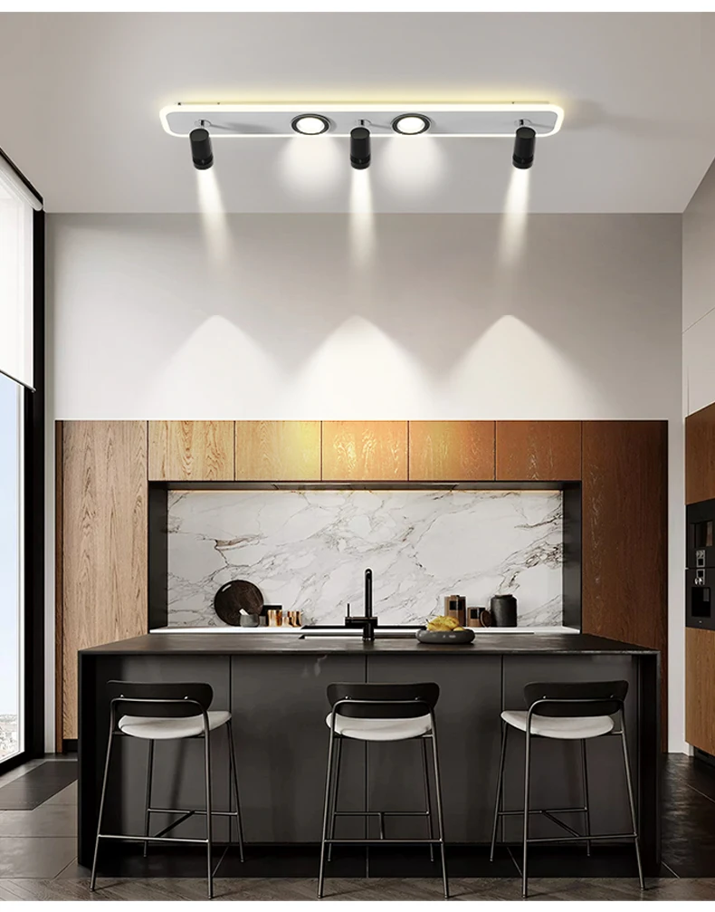 A modern kitchen with a sophisticated ambiance, featuring a bar and stools illuminated by a Track Ceiling Light.