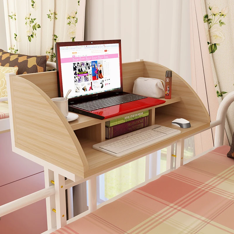 

The computer desk is spread on the desk of college students' dormitory. Lazy people study on the suspended table beside the bed.